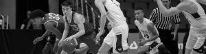 Black and white image of basketball players during a game