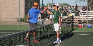 Two players shake hands over the net during a tennis match