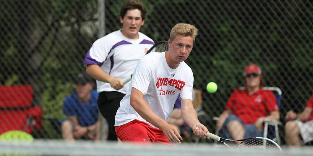 Tennis player hitting the ball mid air