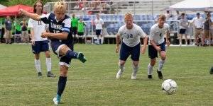 Lions soccer player hitting the ball