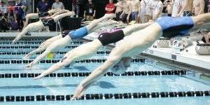Swimmers diving into the water