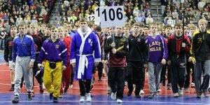Image of students holding up a sign with the number 106 during a wrestling match