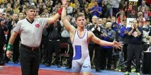 Image of a student and referee with his hands up indicating he won the match