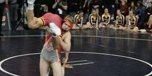 Image of a student with another on his shoulder during a wrestling match