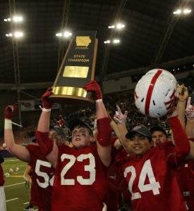 football players holding a state champion trophy