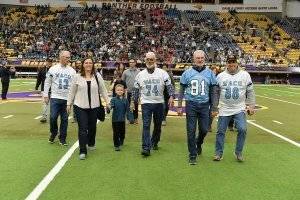 a family walking on a football field in Waco jerseys